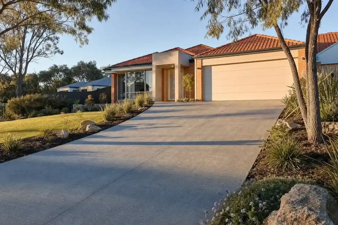 Finished concrete driveway leading up to a modern Perth home in golden afternoon light