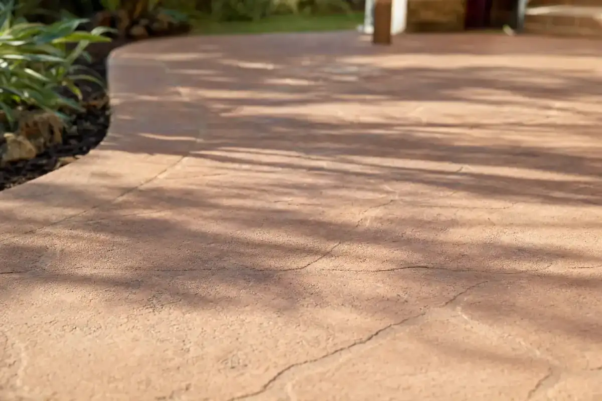 Coloured concrete patio with terracotta tone in Perth backyard, golden afternoon light